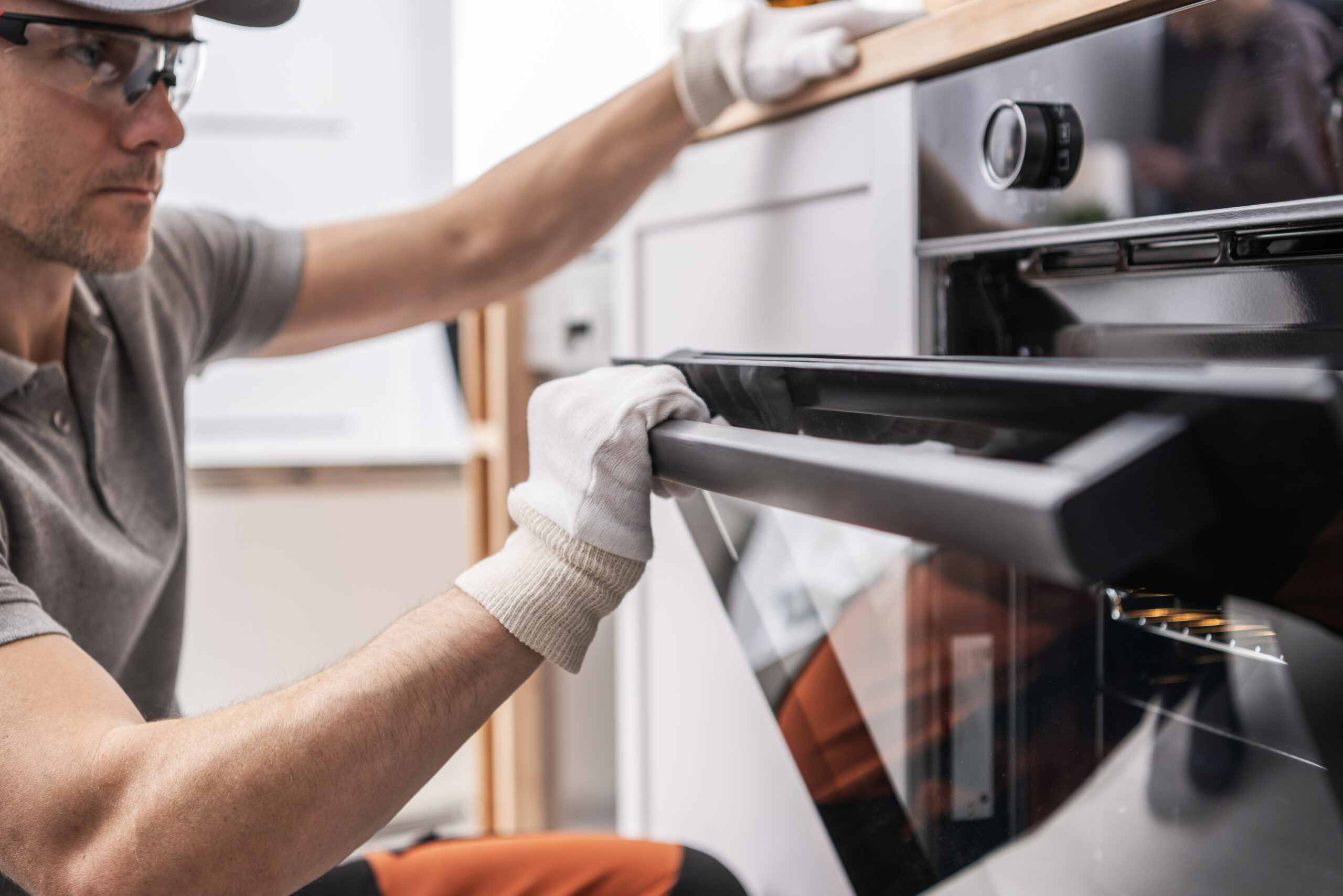 Technician Installing and Testing New Kitchen Stove Technician Installing and Testing New Kitchen Stove